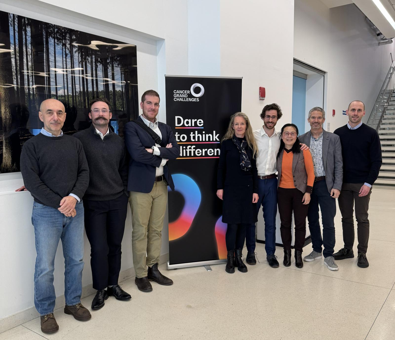 Photo of 8 people standing next to CGC branding
