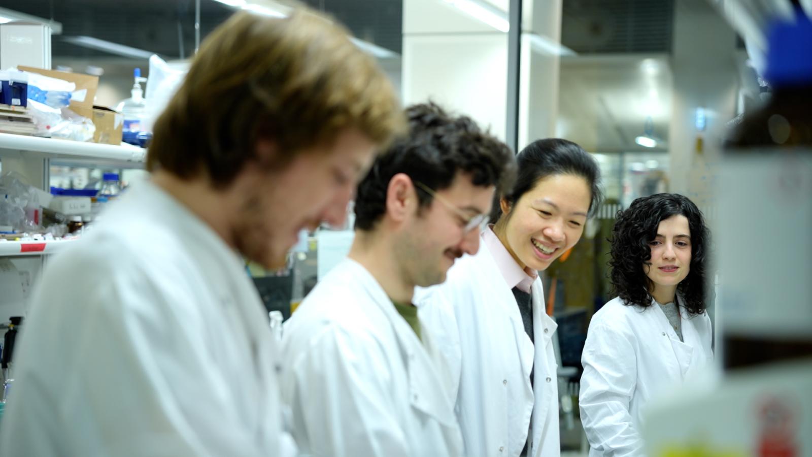 Photo of four people in white lab coats